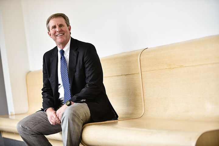 Male, Tim Baldwin stands in front of a presentation screen instructing a classroom.